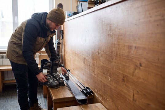 Ski Resort Rental Shop Worker Organizing Winter Sports Boots and Skis