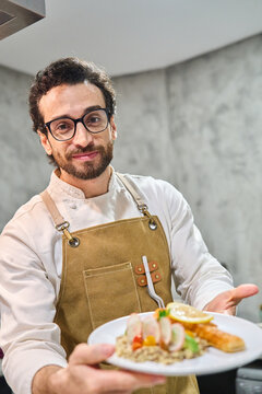 Chef presenting plated gourmet meal with confidence