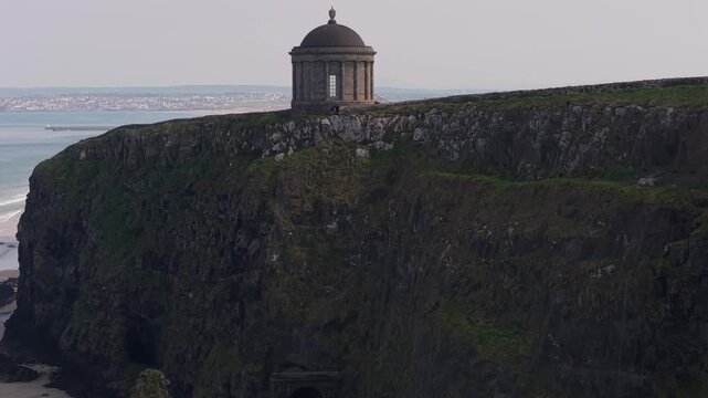 Aerial view of Mussenden Temple perched on the dramatic basalt cliffs overlooking the Atlantic Ocean near Coleraine, Northern Ireland, United Kingdom.
