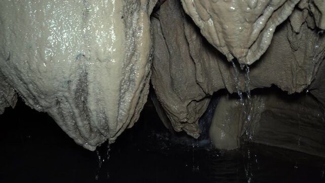 Cave with stalactites in canyon with water at the jungle
