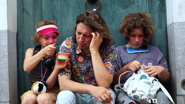 Family resting together with ice cream and smartphone during travel
