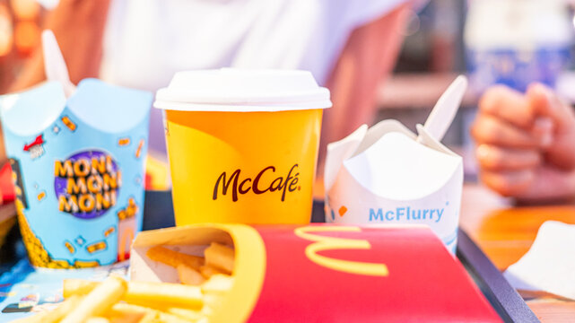 Altea, Spain - August 04, 2026 - McDonalds Fast Food with French Fries, McCafe Coffee and McFlurry Close Up with People in Background
