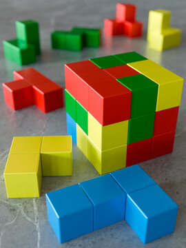 Colorful building blocks arranged in various shapes on a textured surface