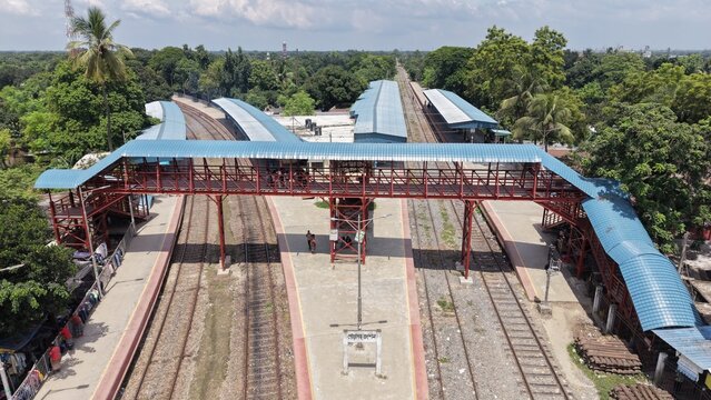 12 August 2026, Poradah Junction, Kushtia, Bangladesh: Aerial view of the railway station showing multiple tracks, covered platforms, a pedestrian footbridge, trees, and surrounding rural landscape.