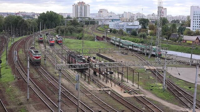 Elevated view of a busy railway station yard with multiple electric trains and locomotives