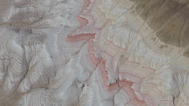 Aerial view of eroded chalky white and pinkish rock formations in the arid desert landscape of Mangistau, Mangystau Region, Kazakhstan.