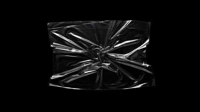 A piece of crumpled transparent plastic texture with folds and creases isolated on a solid black background