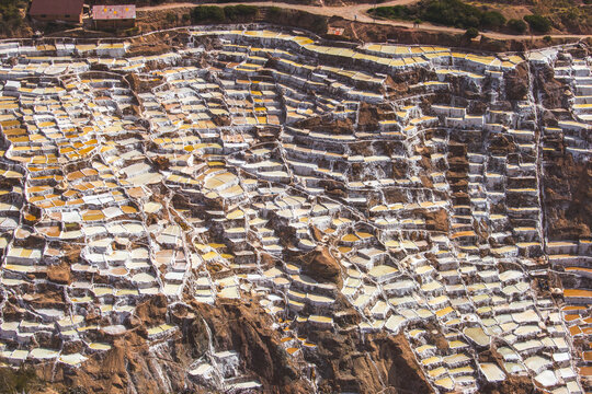 View of Salt Mine of Maras with its intricate network of terraced salt evaporation ponds carved into the hillside in Urubamba, Cusco, Peru.