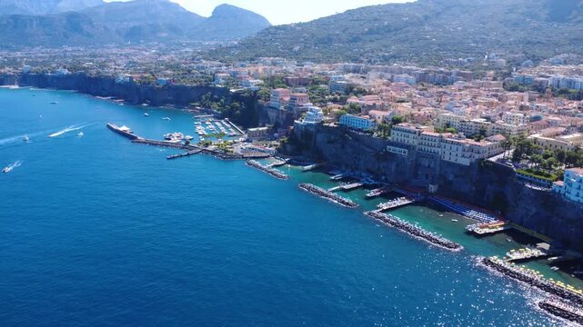 Aerial high-angle flyby over Sorrento seaside cliffs and luxury resorts 4K
