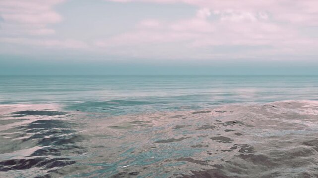Waves roll gently under a cloudy sky. The ocean stretches out in front with a mix of colors. This scene captures the quiet beauty of the coast in the evening light.