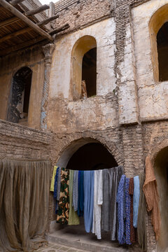 View of laundry hanging on a line against the weathered brick walls and arched doorways of the ancient citadel in Erbil, Erbil Governorate, Iraq.