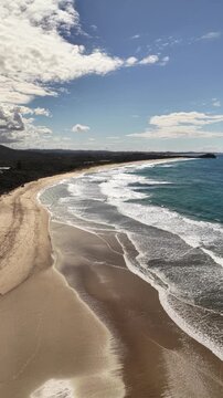 Aerial drone footage of waves washing onto Maggies Beach, Tweed Coast, NSW Australia - vertical video