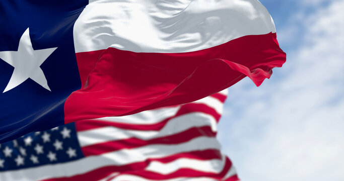 Texas and American flags waving together in blue sky. 3D render