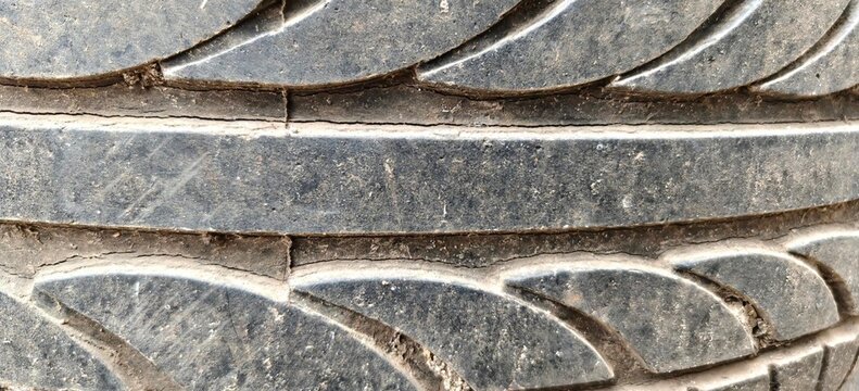 Close up shot of worn rubber car tire tread texture with dirt. Ideal for automotive maintenance, transportation, and safety concepts.
