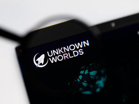 Milan, Italy 2026, 15 AGO Closeup of Unknown worlds website page on a laptop screen. Focus on Unknown worlds logo under a magnifying glass.