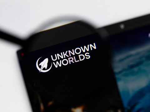 Milan, Italy 2026, 15 AGO Closeup of Unknown worlds website page on a laptop screen. Focus on Unknown worlds logo under a magnifying glass.