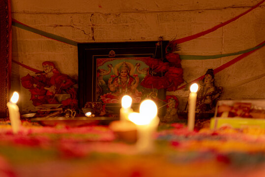 View of a traditional Diwali festival setup with glowing candles and a framed image of Goddess Lakshmi, creating a warm and festive atmosphere in Rahim Yar Khan, Punjab, Pakistan.