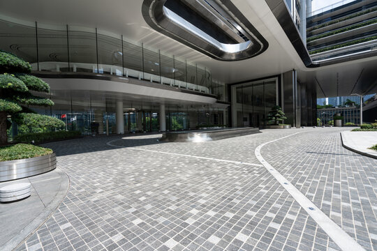 Modern business office building entrance plaza with gray paved ground