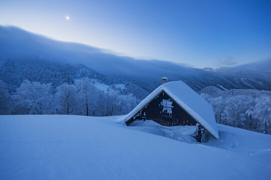 View of the snow-covered Borisov mountain hut nestled in the Velka Fatra mountains with frost-covered trees under a clear blue sky, Velka Fatra mountains, Zilina Region, Slovakia.