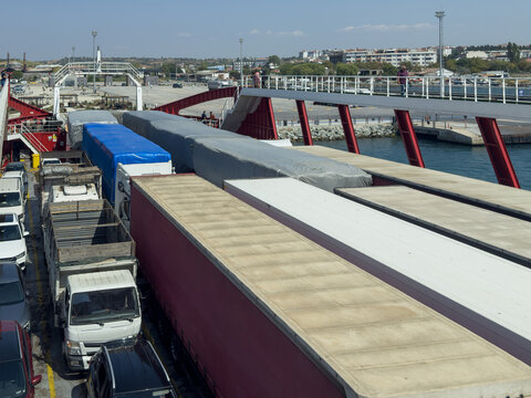 View of trucks and cars parked on a ferry deck with a pedestrian bridge overhead in Canakkale, Canakkale, Turkiye.