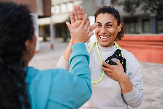 Fitness women athlete congratulating after workout sessions outdoor - Happy senior people training outside - Empowering, healthy lifestyle and sport concept - Main focus on right female face