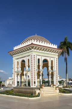 View of the ornate Moorish-style Glorieta de Manzanillo gazebo with intricate tile patterns and a palm tree under a clear blue sky in Manzanillo, Granma, Cuba.