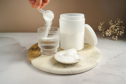 Collagen peptides supplement preparation with powder added to glass of water