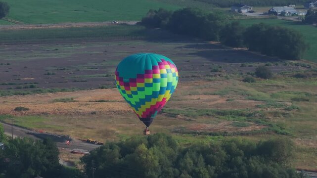 Hot air balloon about to land in a field