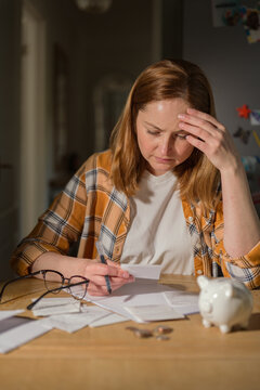 Household budgeting and financial stress concept with woman checking bills at home