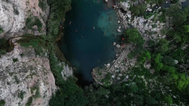 People swimming and relaxing in the water of Swaik Lake in beautiful landscape at Punjab, Pakistan. Aerial view.