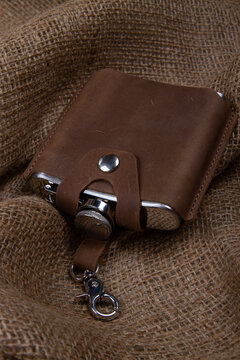 Hip flask in leather case on burlap