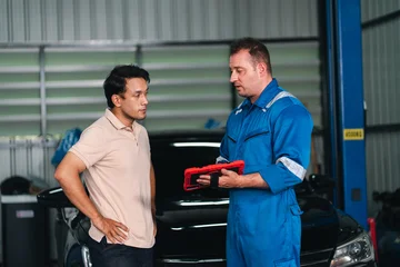 Fotobehang Onderzeeër Electric vehicle battery car service Automotive mechanic showing diagnostic tool to customer inside garage with serious expression during vehicle service consultation  © chokniti
