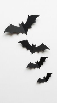 Minimalist Halloween Decoration with Black Paper Bats Flying on White Background - Creative DIY Concept for Spooky Season