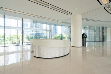 Obraz premium Modern minimalist office reception area with curved white desk and large windows