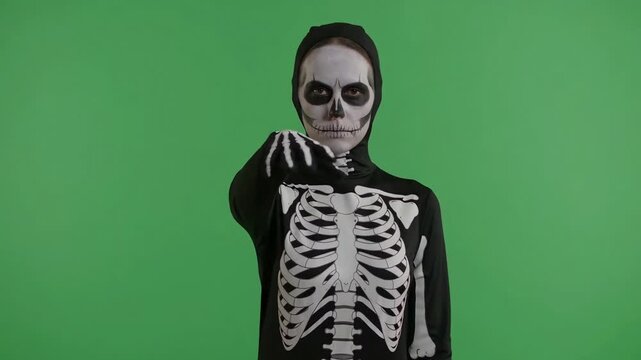 Halloween skeleton costume woman wearing skull makeup posing against green screen for seasonal movie visual effects