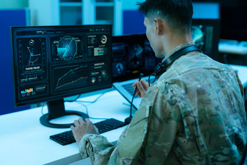 Military air traffic controller monitoring radar flight tracking in a control room, surveillance,...