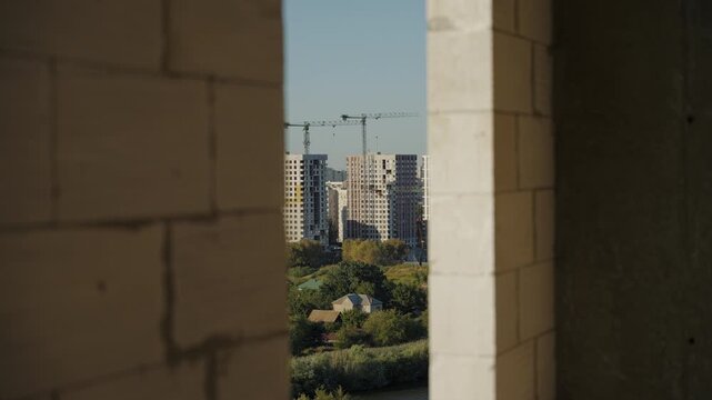 City buildings framed by narrow opening in unfinished construction