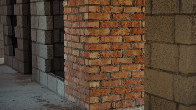 Exposed brick and concrete block walls inside unfinished building