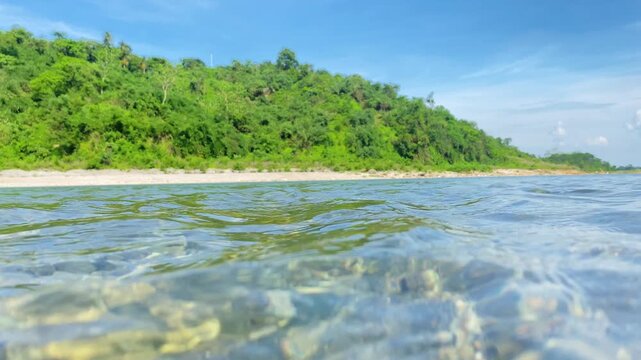 Serene river and lush hills beneath blue sky camera tilt down to underwater at Sada Pathor, bholaganj, Sylhet.