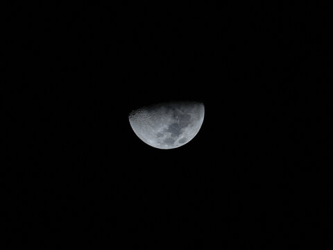 View of the waxing crescent moon shining against the dark night sky over Abu Dhabi, Abu Dhabi, United Arab Emirates.