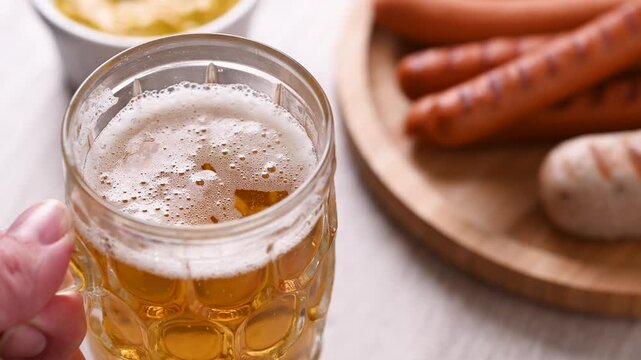 Beer mug placed on table with sausages for Oktoberfest