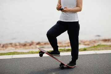 One skateboarder use mobile phone at seaside © lzf
