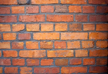 Obraz premium Ściana z czerwonej cegły - różne odcienie od żółtego po bordowy. Red brick wall