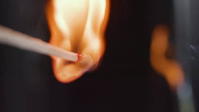 Slow motion close up of striking a match on a matchbox
