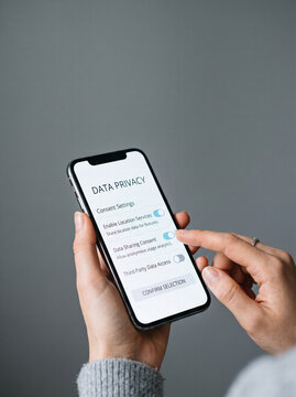 Person Holding Smartphone With Data Privacy Settings On Screen