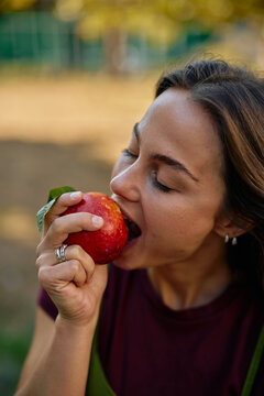Woman biting fresh nectarine in nature