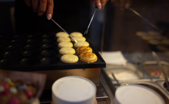 Close-up of mini pancakes cooking on a special molded pan in a restaurant