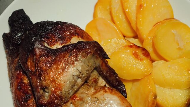 Roasted halal chicken served with golden potatoes, close-up grilled dinner dish. High quality 4k footage