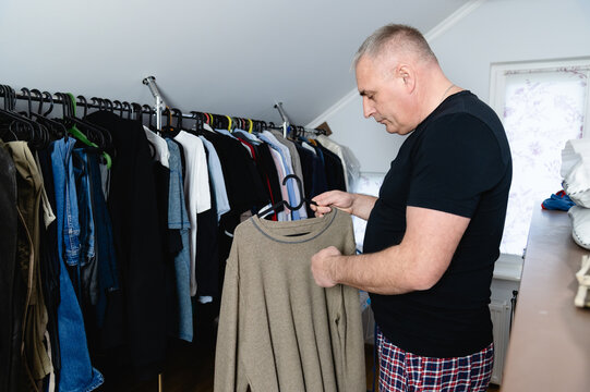 Man organizing clothes in the dressing room closet on a weekend afternoon