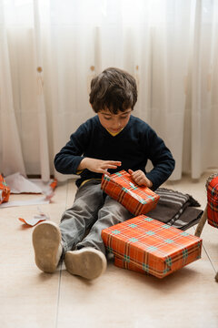 Young child opening christmas gifts from caga tio